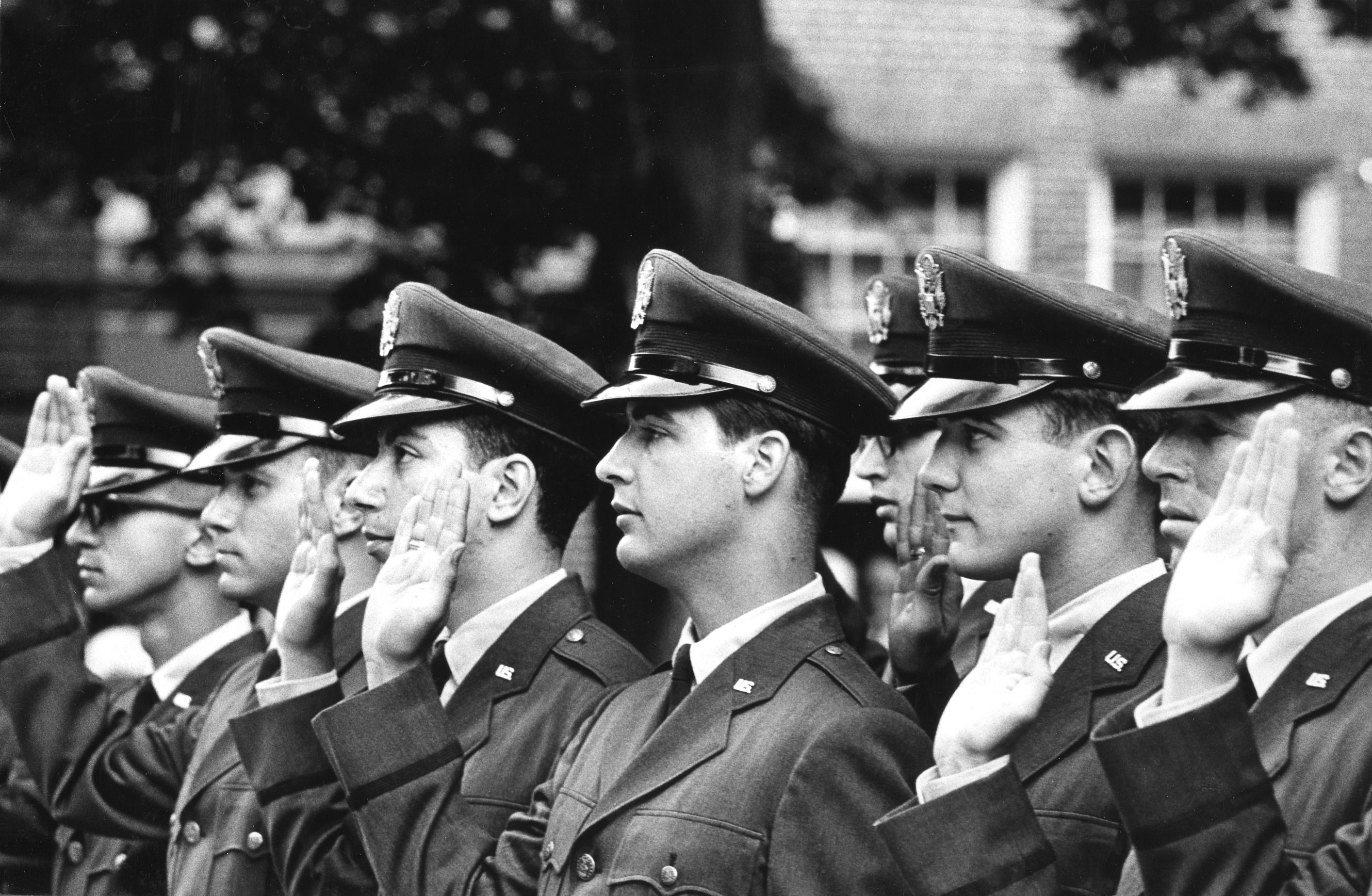 Photograph of students holding their palm up for a swearing ceremony in the 1960s